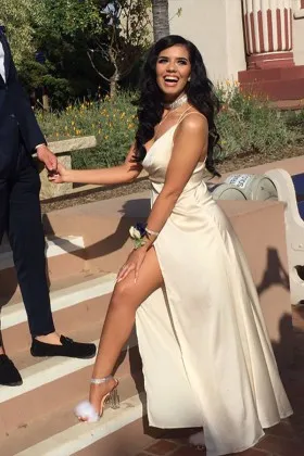Sleek cream satin long prom dress with spaghetti straps and thigh high slit